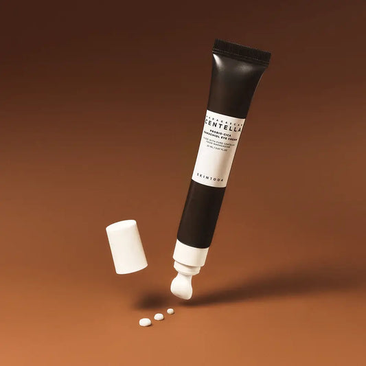 SKIN1004 - Probio-Cica Bakuchiol Eye Cream tube and drops on a brown background.